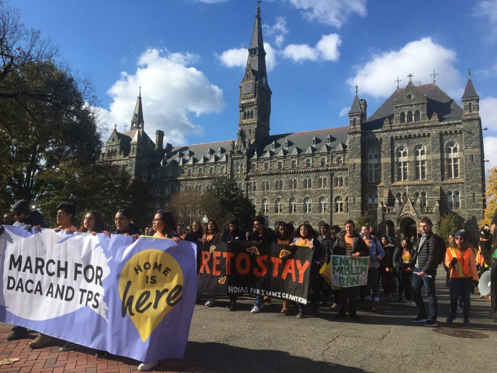 Students walking in protest carrying a banner