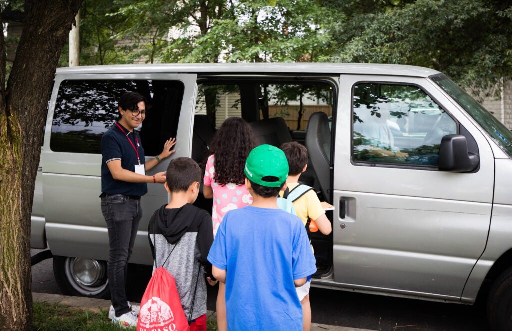 Mentor opening van door for youth