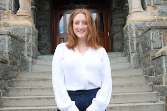 white woman with red hair wearing a white shirt