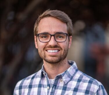 man wearing glasses smiling at the camera