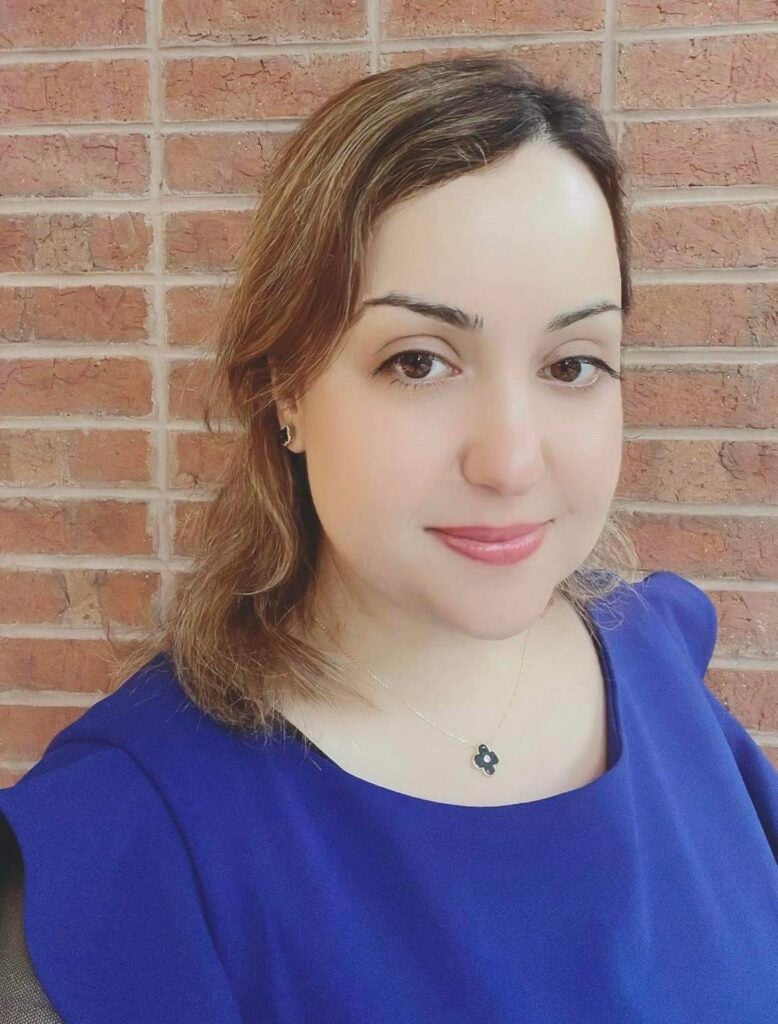 woman wearing blue shirt looking at camera