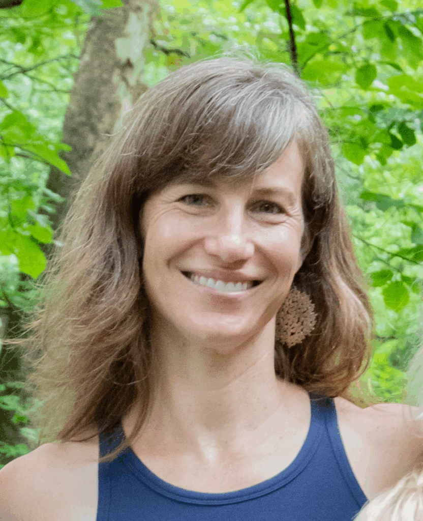 Woman with long hair and earrings smiling at camera