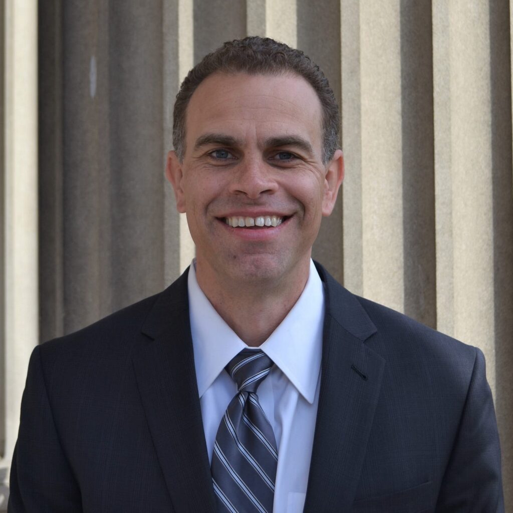 man wearing a suit smiling at the camera
