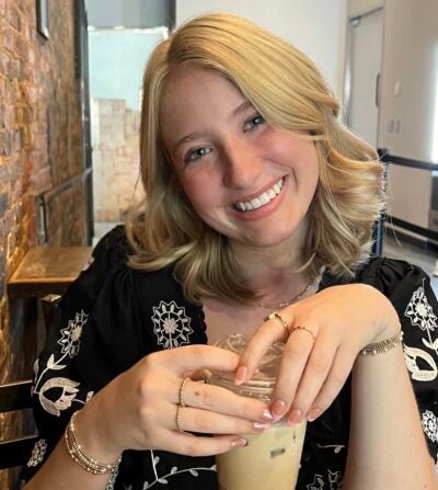 Woman smiling at camera holding coffee