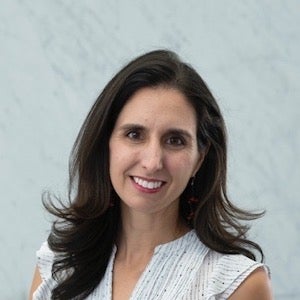 woman with long brown hair smiling at camera
