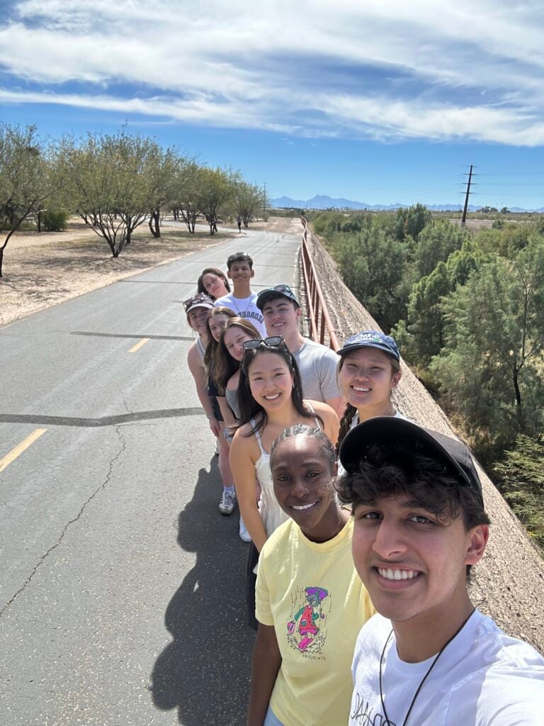 group of students standing in a line on a highway on the US/Mexico border