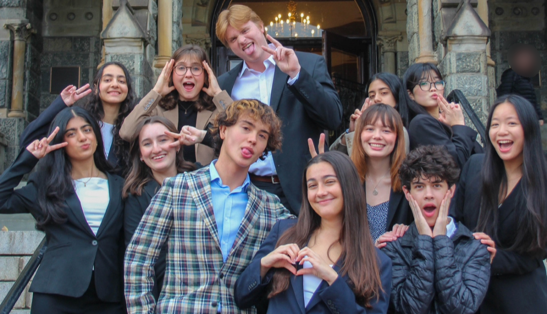 A diverse group of young people smiling and posing together for a photo outdoors.